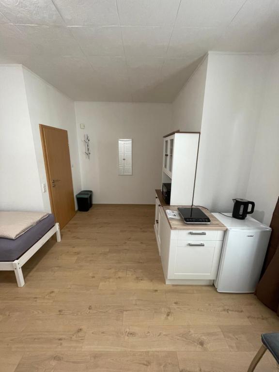 Habitación vacía con cama y cocina en Varus Apartments, en Detmold