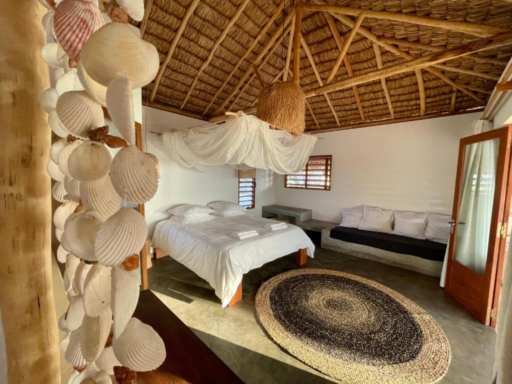 a bedroom with a bed and a large rug at LA DUNE DES SONGES in Anakao