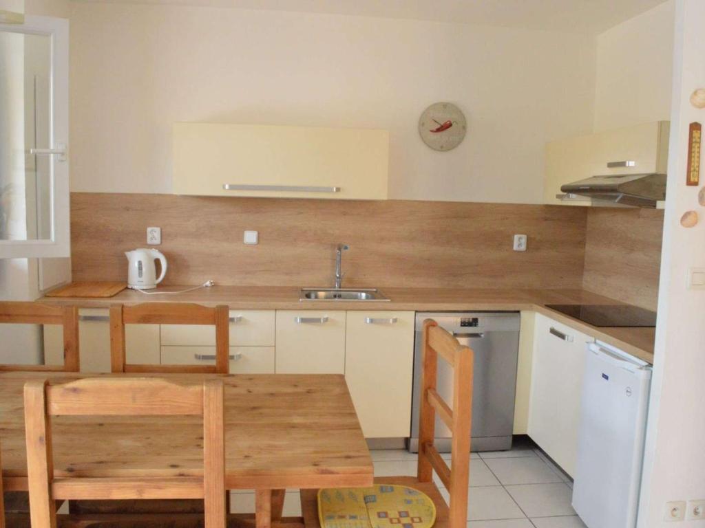 eine Küche mit einem Tisch, Stühlen und einem Waschbecken in der Unterkunft Maison Narbonne, 3 pièces, 5 personnes - FR-1-229B-40 in Narbonne