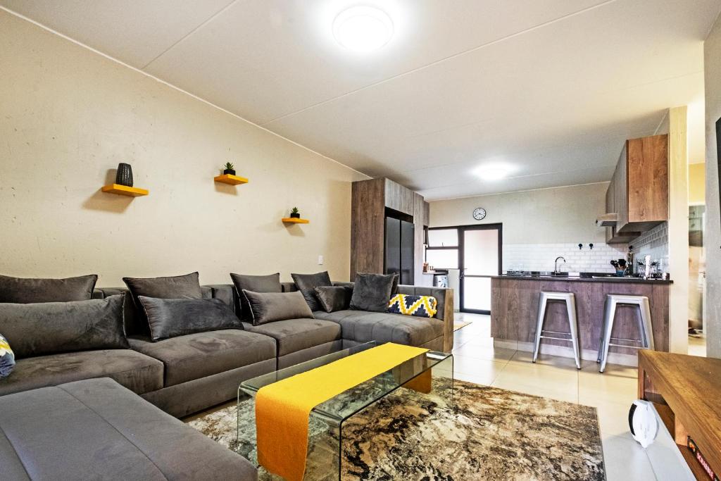 a living room with a couch and a kitchen at Airport Heights in Boksburg