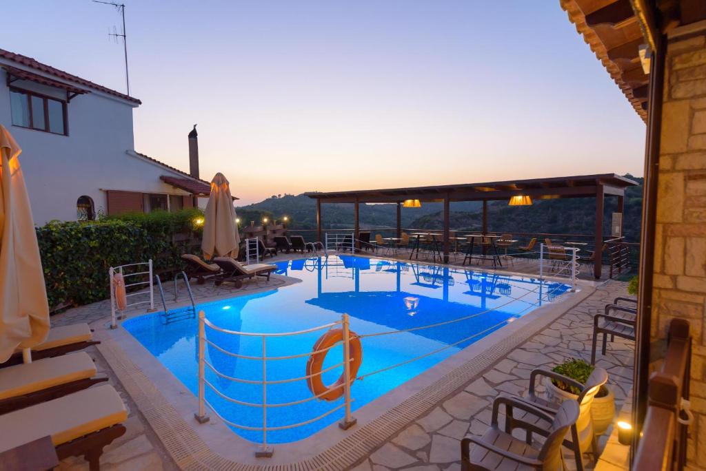 a large swimming pool with chairs and umbrellas at Bacchus Villa in Archea Pissa