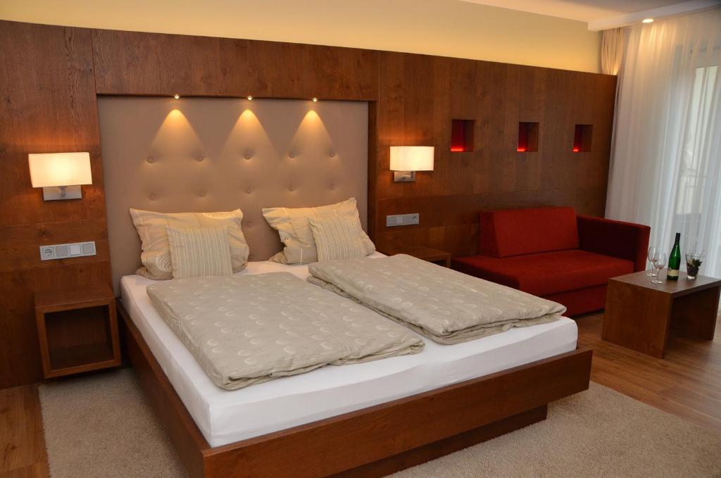 1 dormitorio con 1 cama grande y 1 silla roja en Seminarshof, en Trittenheim