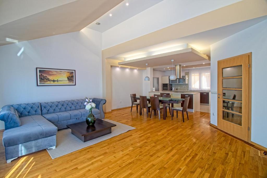 a living room with a blue couch and a table at Stross Apartments & Rooms in Osijek