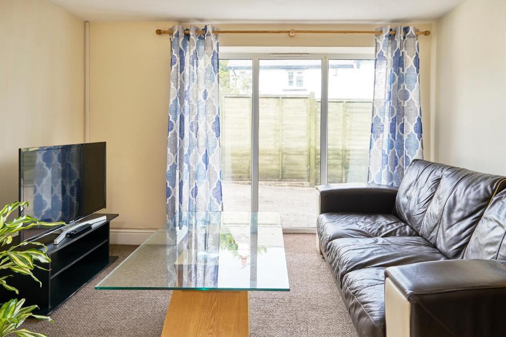 a living room with a couch and a glass table at The Barn (Chilsworthy), 6 Sleeper House, 19 Min Drive into Bude, Cornwall in Holsworthy