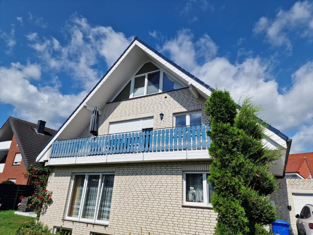 ein weißes Backsteinhaus mit einem blauen Balkon in der Unterkunft Haus der Erholung App OG in Lotte