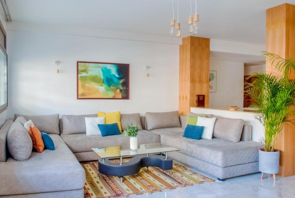 a living room with two couches and a table at Luxury Apartment 3 Bedroom in the Heart of Agdal near Arribat Center in Rabat