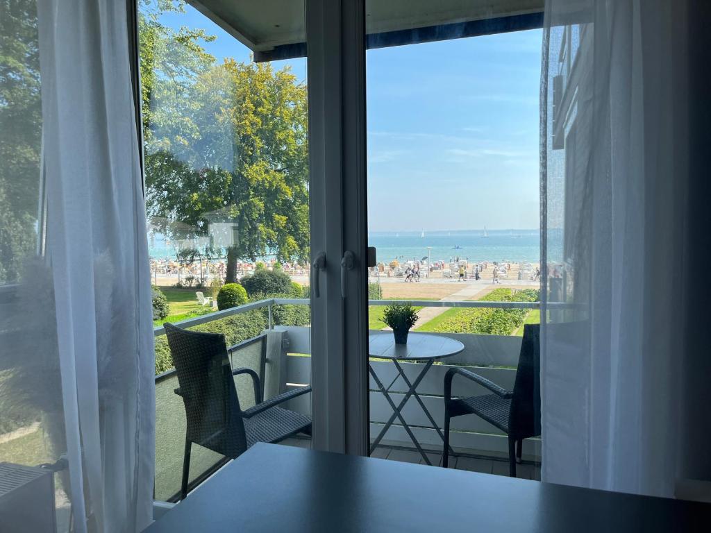 einen Balkon mit einem Tisch und Stühlen sowie Strandblick in der Unterkunft Wohlfühl Strand Wohnung 'Mein Ankerplatz' in Lübeck