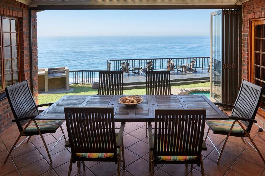 uma mesa e cadeiras num pátio com vista para o oceano em Garvies Surf house em Durban