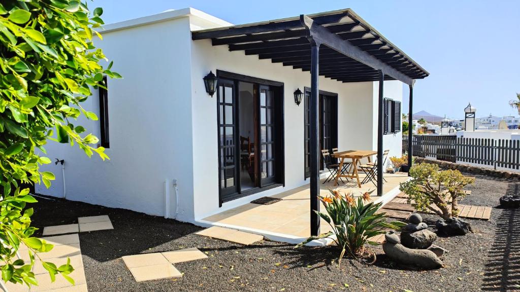 a small white house with a black roof at Casa Julia in Tías