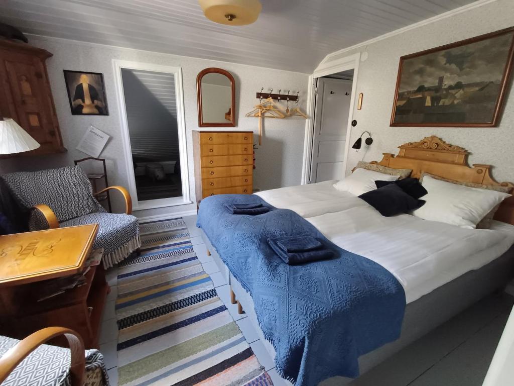 Un dormitorio con una cama grande con una manta azul. en Flodhästens Husrum & Frukost, en Varberg