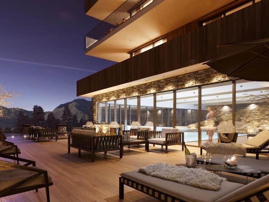 un bâtiment avec des tables et des chaises sur une terrasse dans l'établissement Appartement Haute gamme ski aux pieds, piscine, sauna., à Bourg-Saint-Maurice