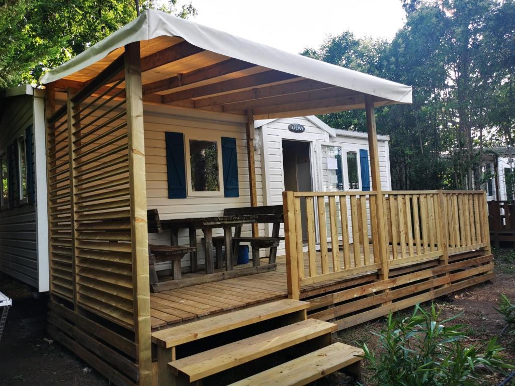 une terrasse en bois avec une table et une tente dans l'établissement Vacances en Provence, à La Roque-dʼAnthéron