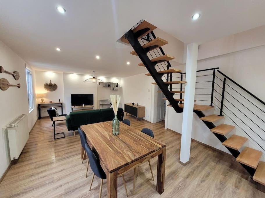 salon ze stołem i spiralnymi schodami w obiekcie Splendide Duplex w mieście Saint-Dizier