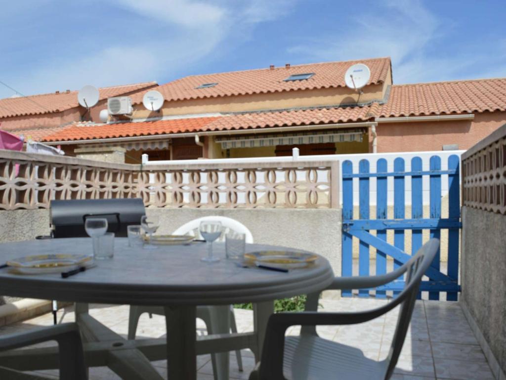 stół i krzesła na balkonie z ogrodzeniem w obiekcie Pavillon avec Terrasse, 6 couchages, à 250m de la Plage et 600m des Commerces - Narbonne Plage - FR-1-229B-68 w mieście Narbona