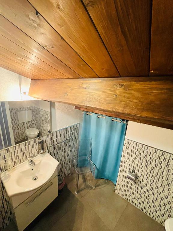 łazienka z umywalką i niebieską zasłoną prysznicową w obiekcie San Nicolò Holiday Home w mieście Montalbano Elicona