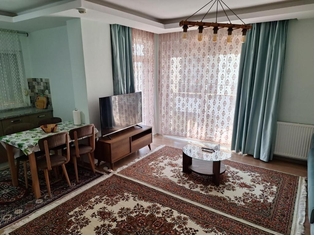 a living room with a table and a television and a dining room at Family Apart-Hotel 2022 - 6 in Antalya