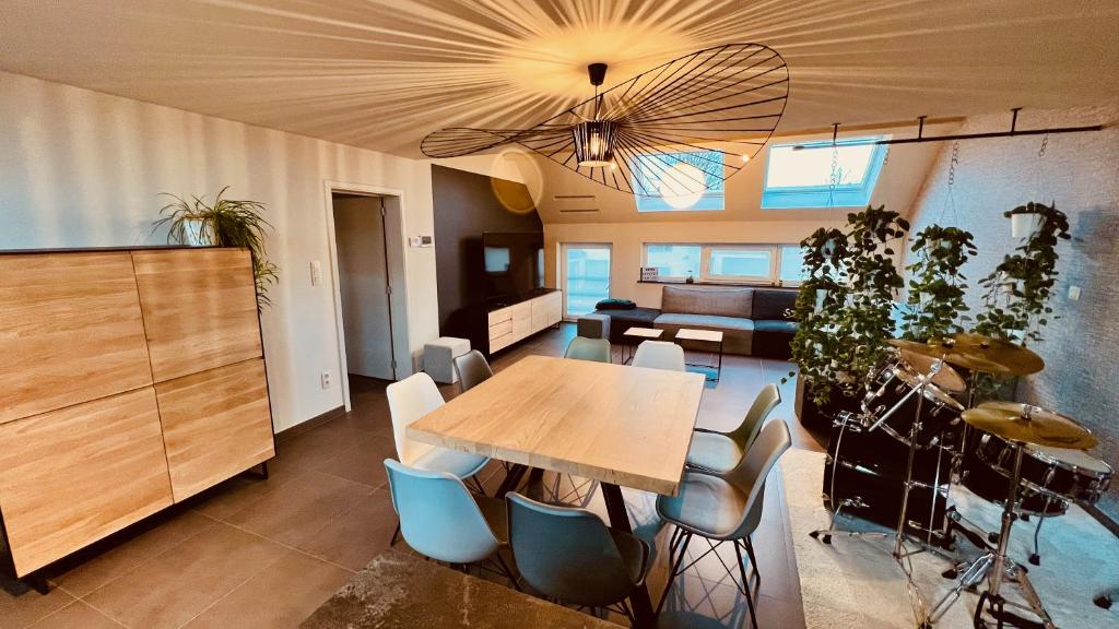uma sala de jantar com uma mesa de madeira e cadeiras em BeCosy Triplex chic et moderne style Loft em Beloeil