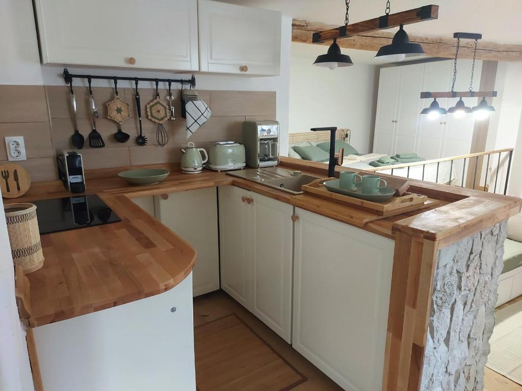 a kitchen with white cabinets and a wooden counter top at Studio al Mulino in Rovinj