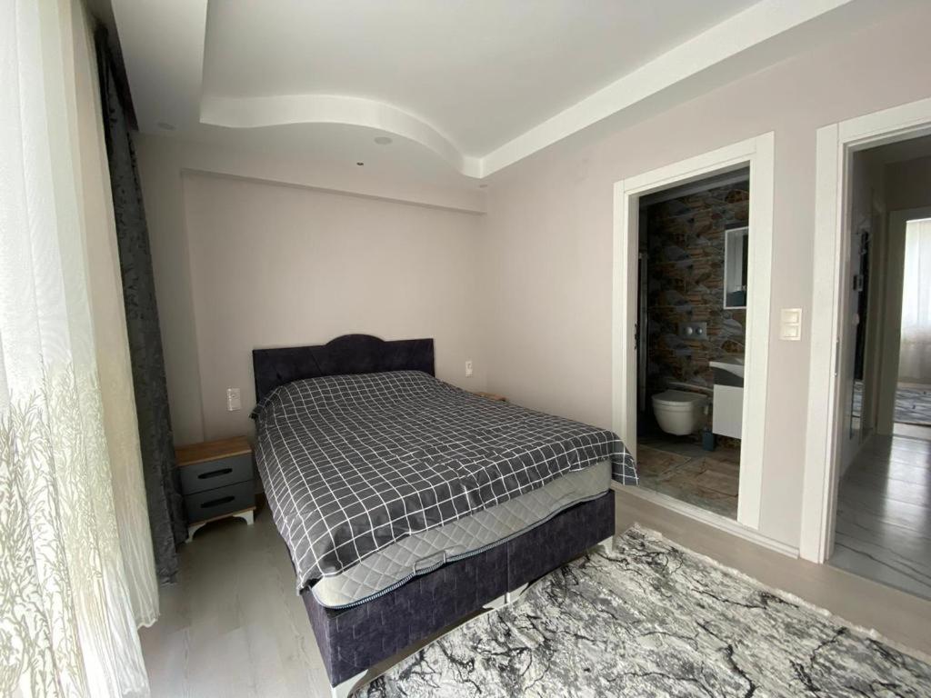 ein Schlafzimmer mit einem Bett in einem Zimmer in der Unterkunft DALAMAN 2+1 GENİŞ KİRALIK DAİRE in Dalaman