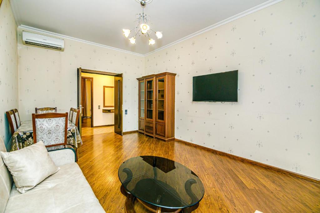 een woonkamer met een bank en een tafel bij Apartment Lux in Baku