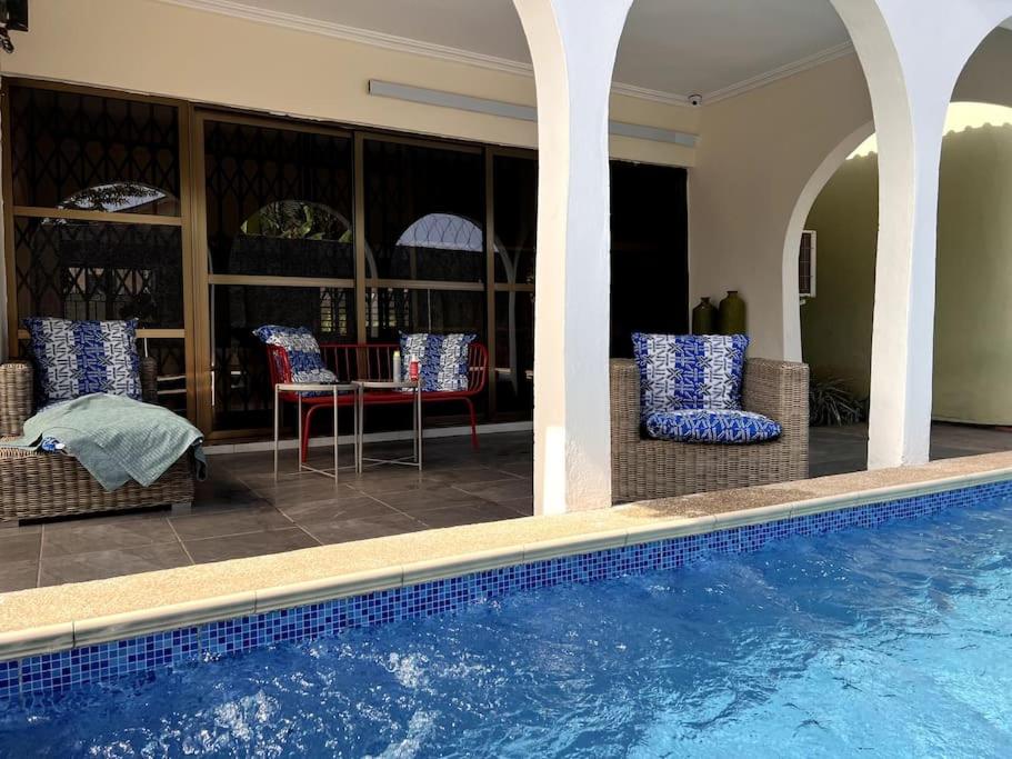 Casa con piscina, sillas y mesa en Relaxinhaatso - 4 Bedroom luxury house with pool, en Haatso