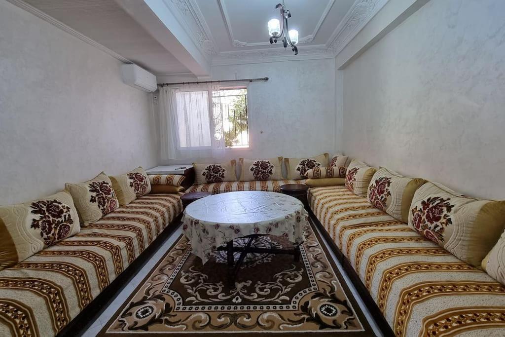 Airport apartment في مراكش: غرفة معيشة مع أريكة وطاولة