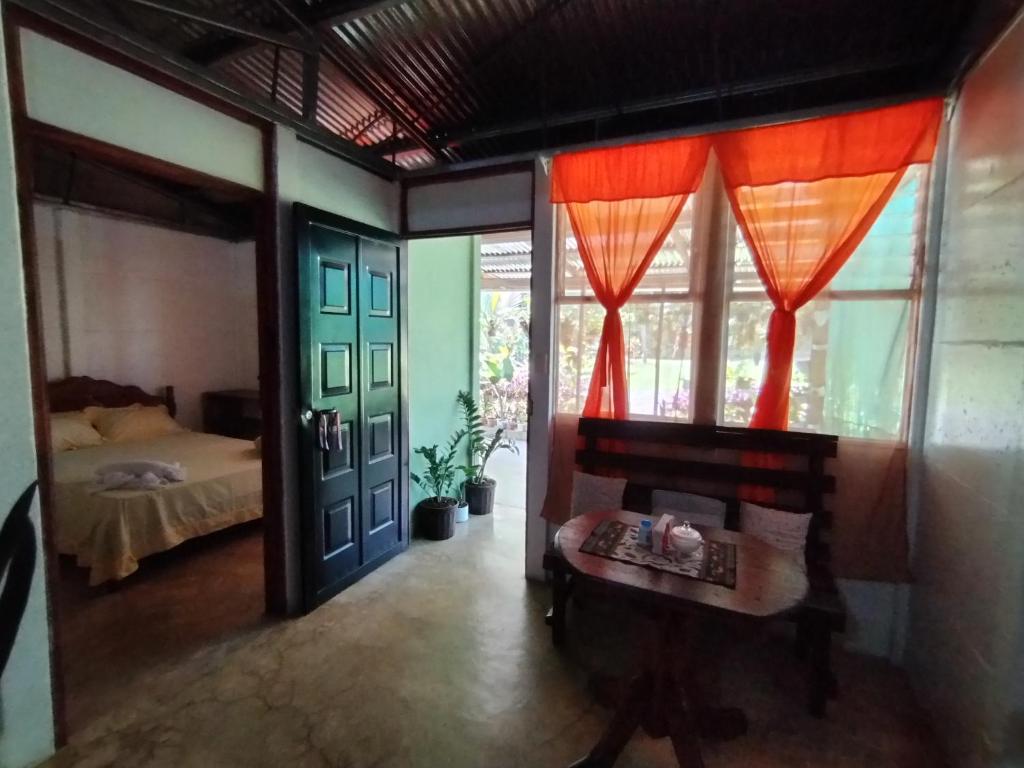 een slaapkamer met een bed en een tafel en ramen bij Maricel House in San Rafael