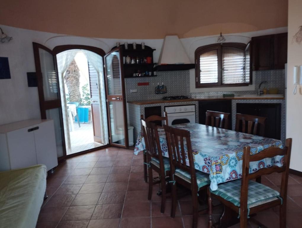 une cuisine avec une table et des chaises ainsi qu'une porte ouverte dans l'établissement Venere Holidays, à Altavilla Milicia