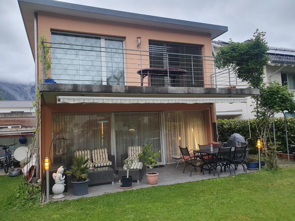 a house with a balcony with a table and chairs at Casa Nadja, nähe Skigebiet Flims-Lax in Ems