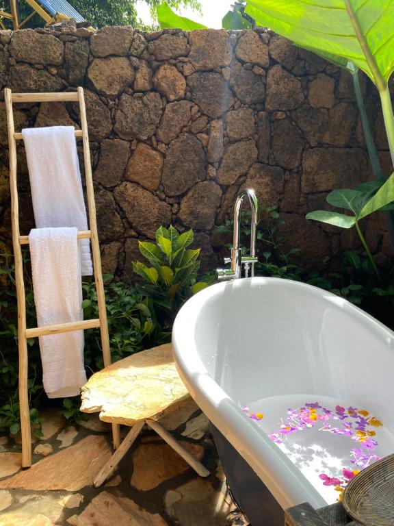 uma casa de banho com uma banheira e uma cadeira em Mabamba Lodge em Wakiso