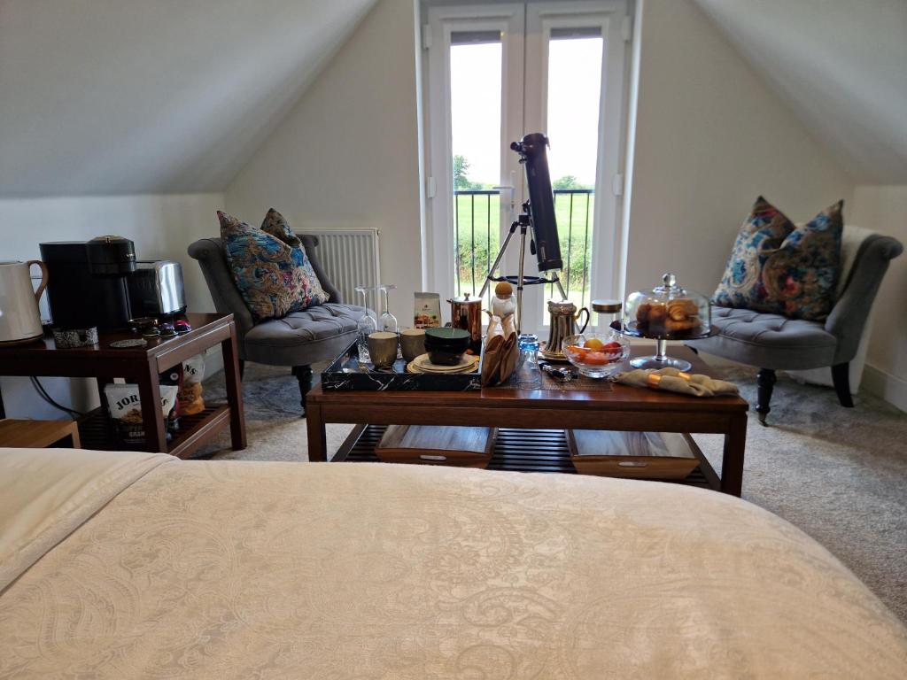 una camera con letto, tavolo e sedie di Hillvine a Hartpury
