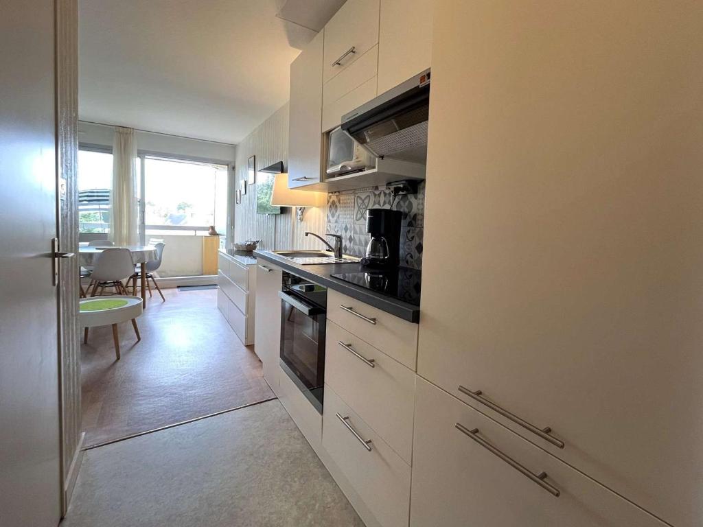 kuchnia z białymi szafkami i piekarnikiem w obiekcie Studio cosy à Bénodet: plage, restos, thalasso à pied, balcon et parking privé - FR-1-481-135 w mieście Bénodet