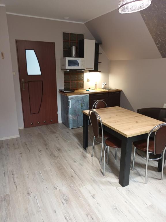 a kitchen and dining room with a table and chairs at UROCZYSKO POD LASEM in Mikoszewo