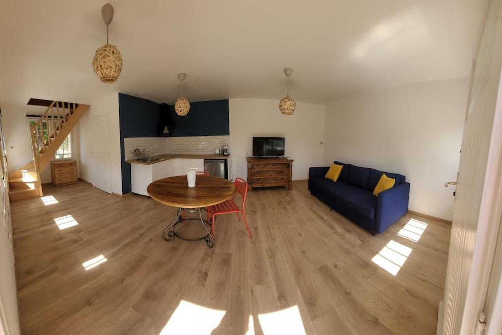 ein Wohnzimmer mit einem Tisch und einem blauen Sofa in der Unterkunft Au cœur des châteaux de la Loire in Saint-Avertin