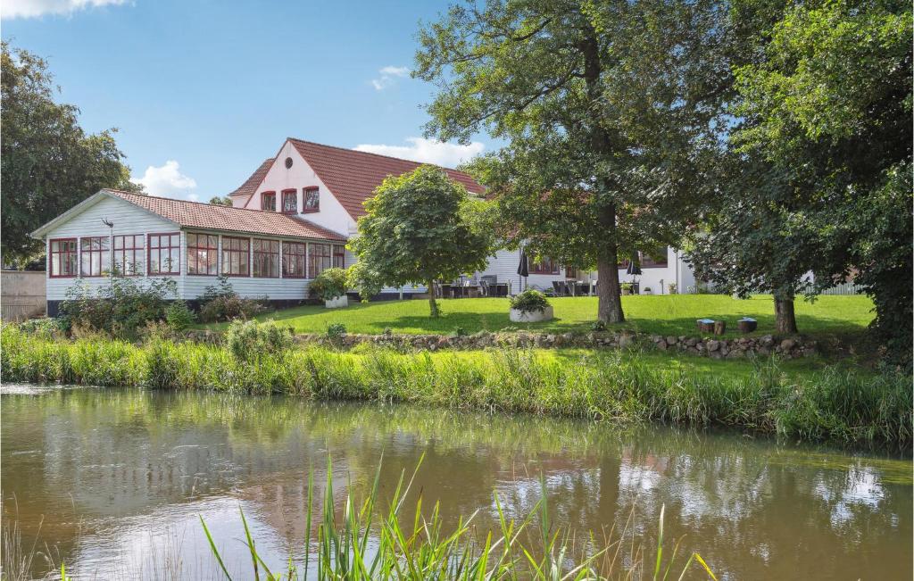 a house next to a river with a building at Foldingbro Kro in Lintrup