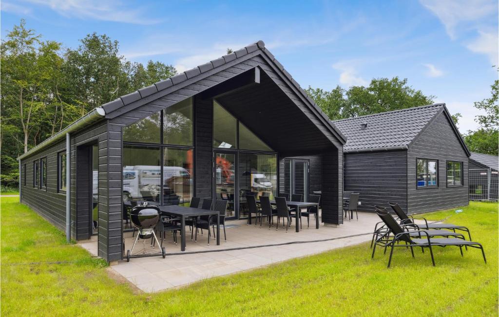 a black house with a patio and tables and chairs at Aqua 221 in Charlottenthal