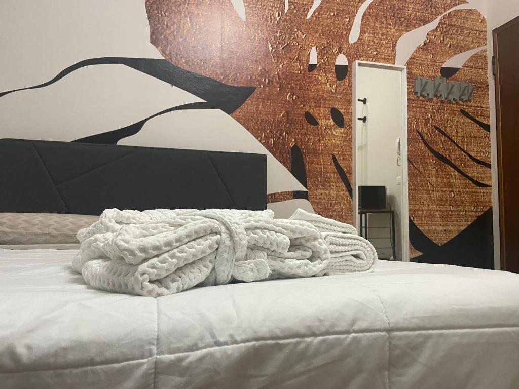 a bed with a white blanket on top of it at Cucchiari Suite 8A in Modena