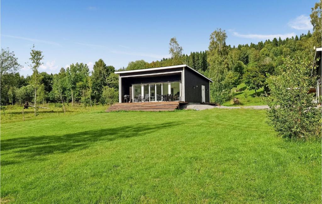 uma casa preta num campo com um grande quintal em Stunning Apartment In Charlottenberg With Kitchen em Charlottenberg