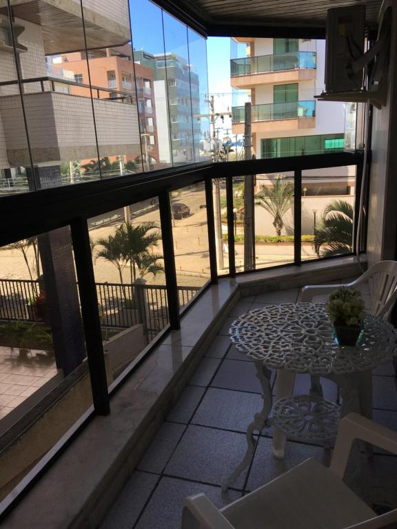 einen Balkon mit einem Tisch und Stühlen sowie Aussicht in der Unterkunft Apto MAR AZUL CARIBE - PRAIA DO FORTE - 3 minutos a pé da praia in Cabo Frio