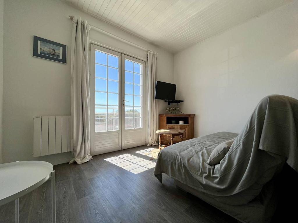 une chambre avec un lit et une grande fenêtre dans l'établissement Appartement rénové 3 ch, parking, proche plage – Saint-Pierre-d’Oléron - FR-1-246A-269, à Saint-Pierre-dʼOléron
