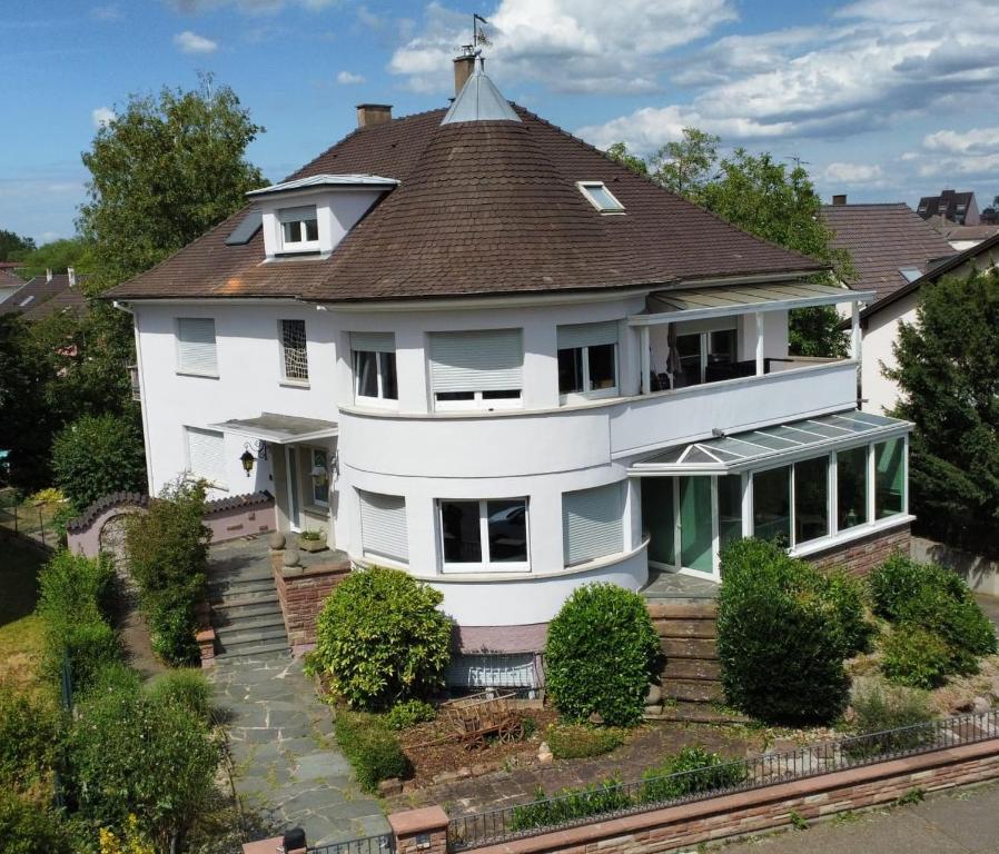 ein großes weißes Haus mit braunem Dach in der Unterkunft La Tour de l'Ill in Straßburg