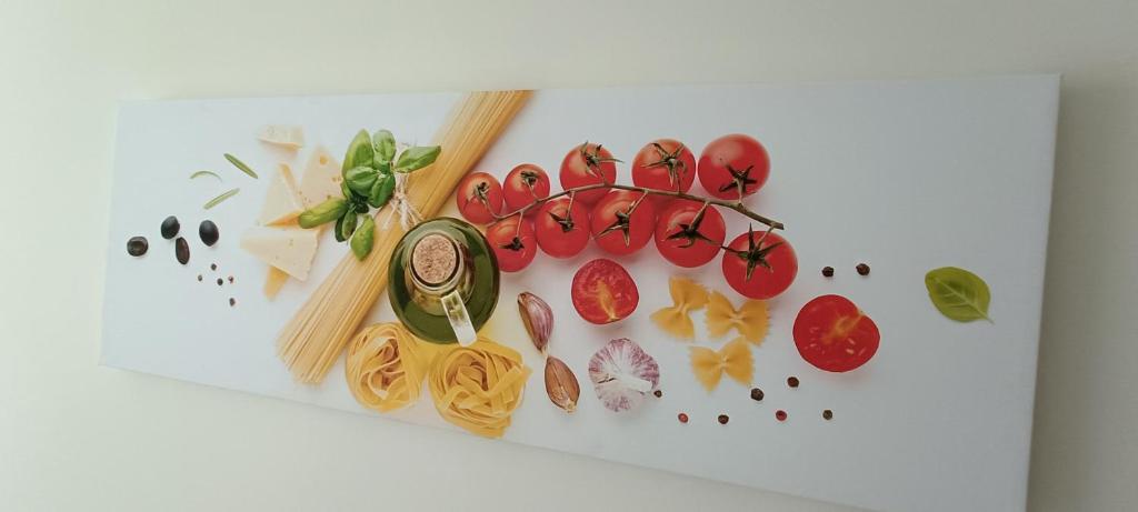una tabla blanca de cortar con pasta y verduras. en 54 ONE by RW San Julian's, en San Julián