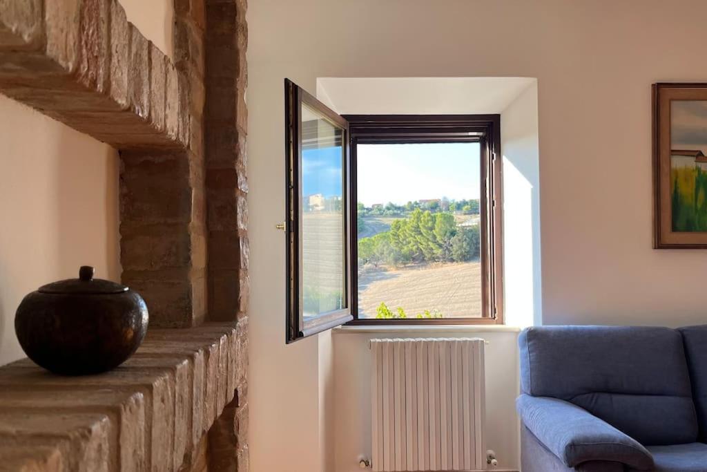 a living room with a blue couch and a window at [Appartamento con vista] Finestra sulle colline in Fermo