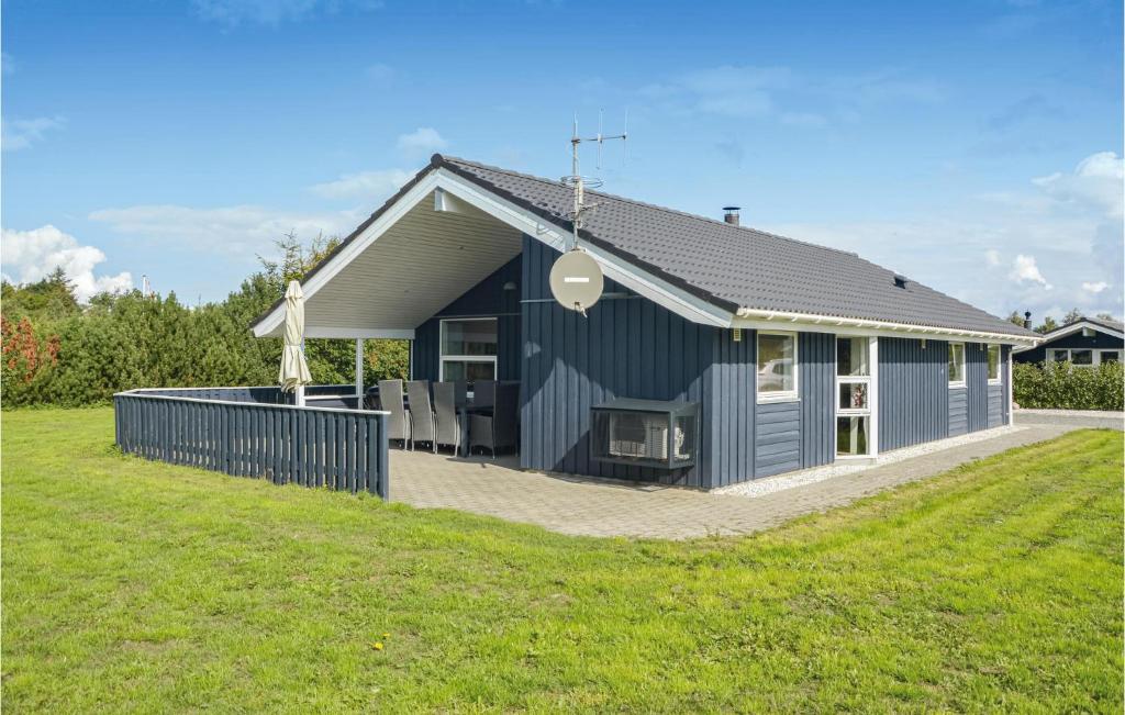 ein blaues Haus mit Rasen davor in der Unterkunft Holiday Home Fasanvænget Hemmet I in Hemmet