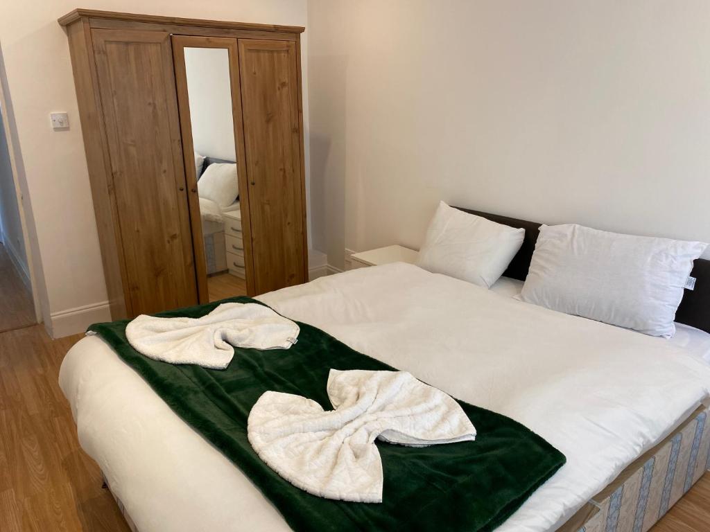 a bed with two towels sitting on top of it at The London apartment in London