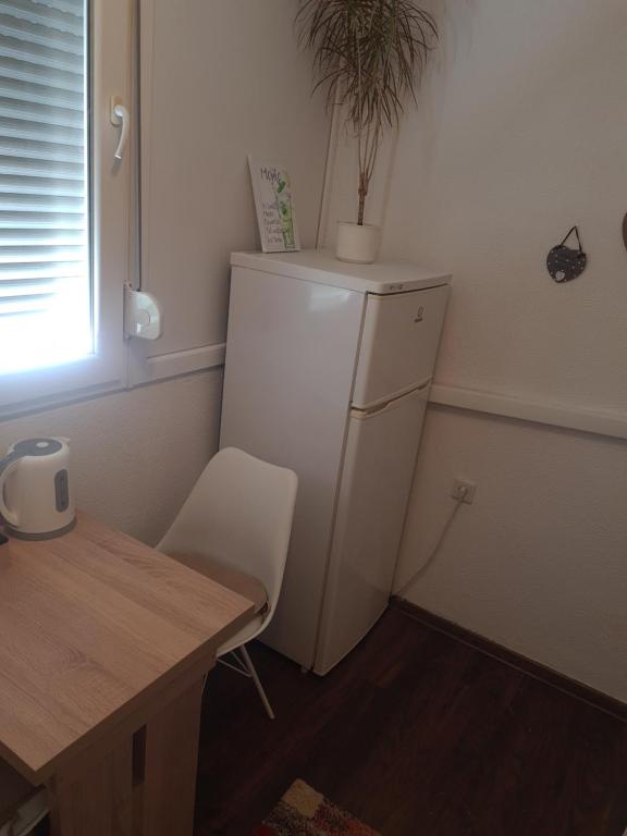 a small kitchen with a white refrigerator and a table at Kineski zid in Zenica