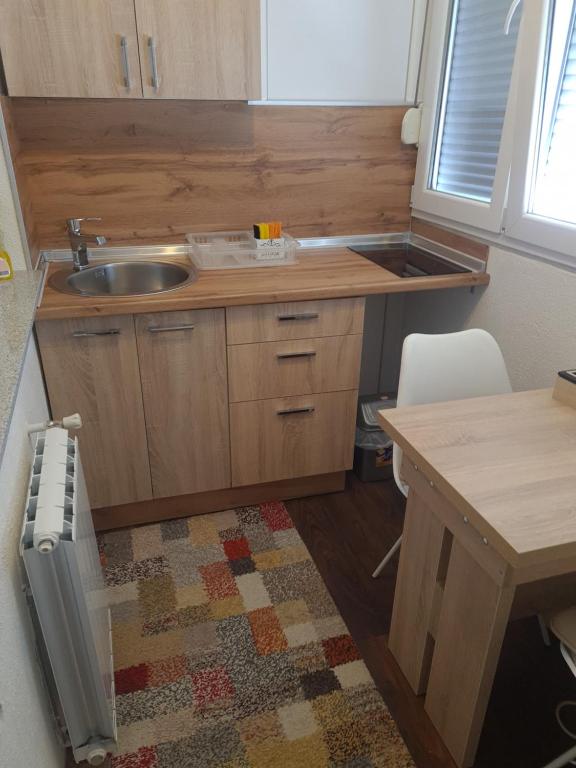 a small kitchen with a sink and a table at Kineski zid in Zenica