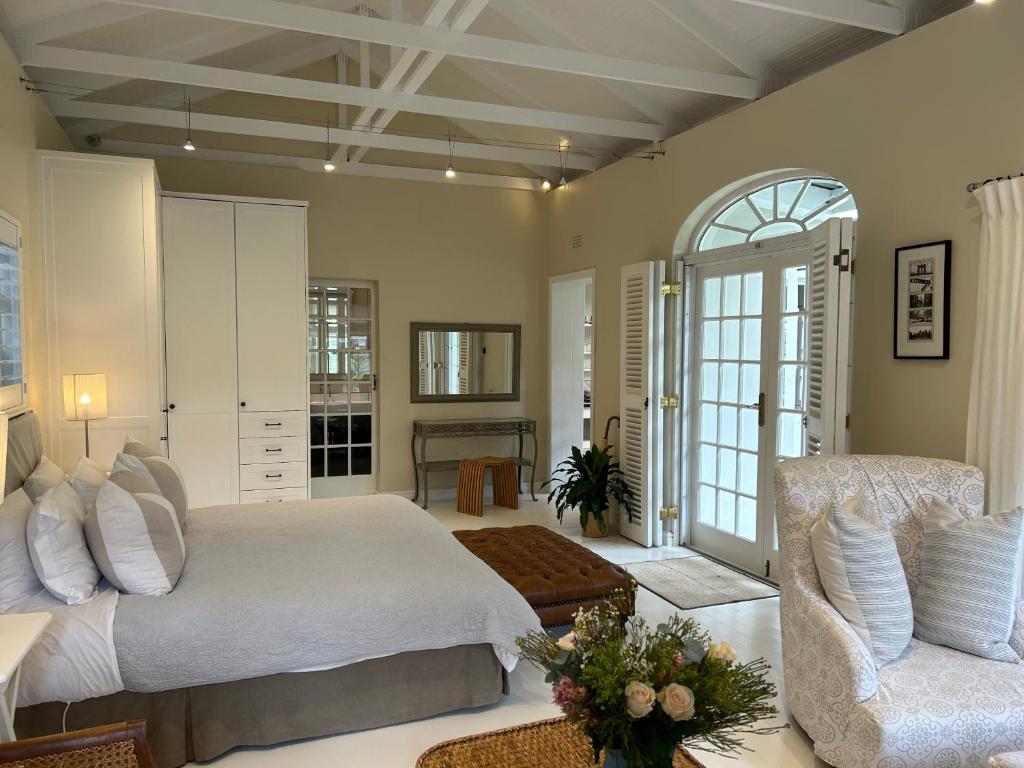 a bedroom with a white bed and a chair at Chambery in Cape Town