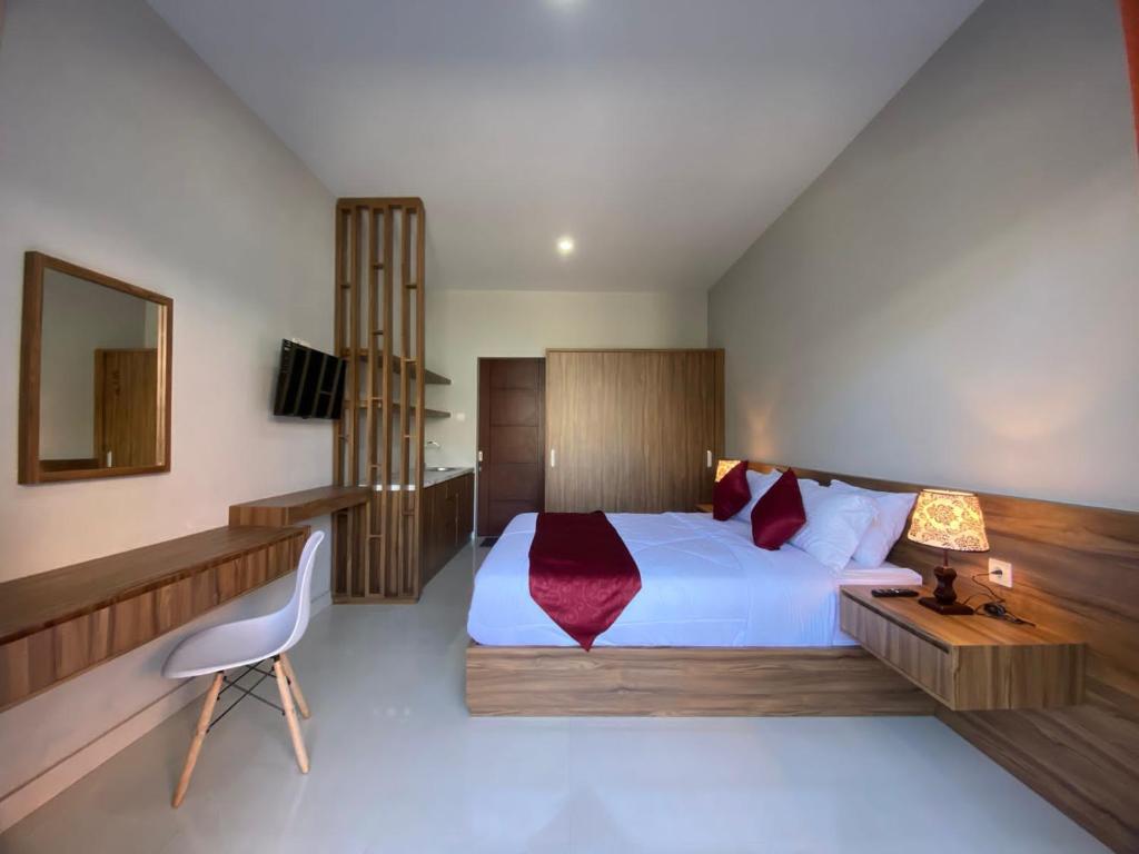 a bedroom with a large white bed and a chair at Pondok Puspa Sumekar in Seminyak