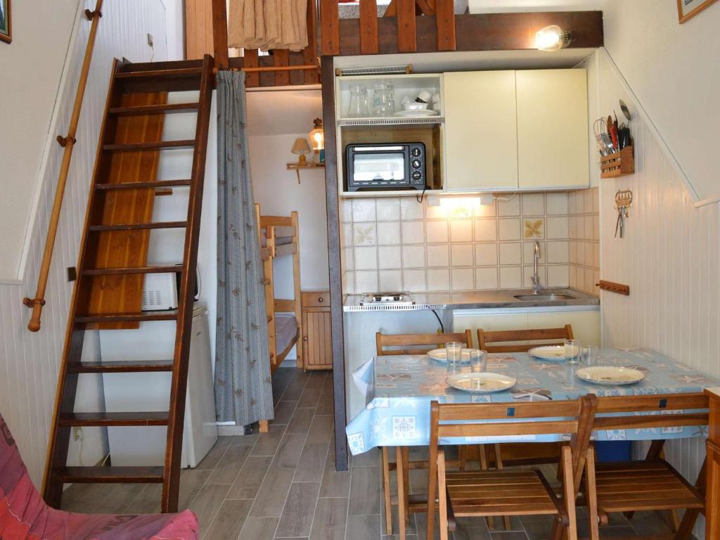 een kleine keuken met een tafel en stoelen en een ladder bij Maison Fleury-Saint-Pierre-la-Mer, 1 pièce, 4 personnes - FR-1-229D-309 in Saint Pierre La Mer